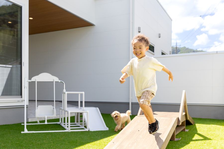 庭を思いきり走り回る子どもと愛犬。